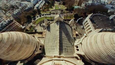 Tilt-up-zoom-in-above-Louvre-Paris-overlooking-people-walking-outside-on-street