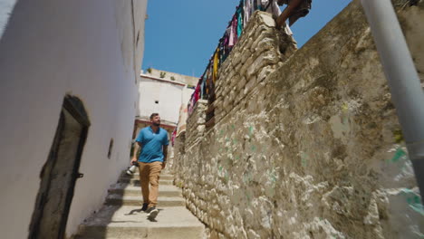 Clothes-Hanging-At-The-Entrance-of-Casbah-Of-Algiers-With-Male-Photographer-Walking-Down-The-Stairs
