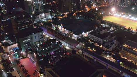 Aerial-View-Of-Train-Station,-City-Buildings-And-Soemantri-Brodjonegoro-Stadium-At-Night-In-Jakarta,-Indonesia
