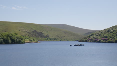 Panoramic-View-of-Meldon-Reservoir,-With-Platform-and-Bois-on-Water-and-Lush-Green-Hills-in-Distance,-Dartmoor,-England