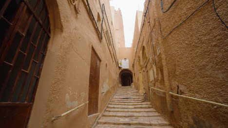 Tourist-With-Modern-Camera-Walking-From-The-Arched-Thoroughfare-In-Ghardaia-City,-Sahara-Desert,-Algeria