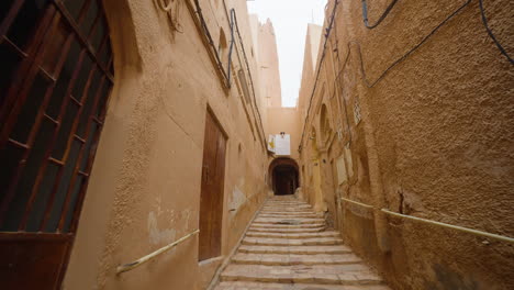 Turista-Con-Cámara-Moderna-Caminando-Desde-La-Calle-Arqueada-En-La-Ciudad-De-Ghardaia,-Desierto-Del-Sahara,-Argelia