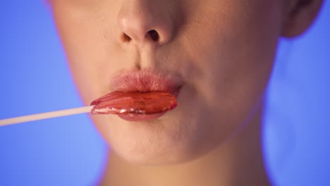 Woman-licking-a-lollipop,-close-up-portrait