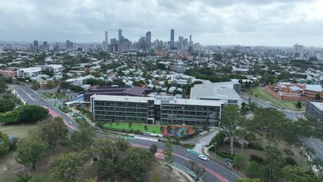 Establishing-drone-shot-of-Brisbane-South-State-Secondary-College,-drone-pull-away-shot-with-Brisbane-City-CBD,-Dutton-Park,-West-End,-South-Bank-in-background