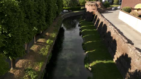 Flug-über-Dem-Kanalwasser-Entlang-Der-Mauer-Von-Bastioni-Balestrieri-In-Soncino,-Italien