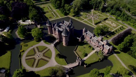 Contrasting-pan-rotating-aerial-around-historic-picturesque-castle-Ter-Haar-in-Utrecht-with-typical-towers-and-fairy-tale-facade-exterior-on-a-bright-day-with-landscaping-gardens-in-the-foreground