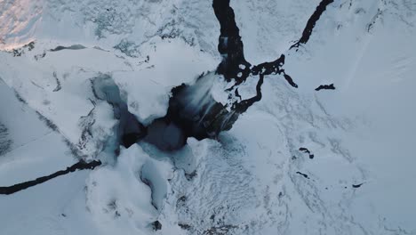 Luftaufnahme-Einer-Schneebedeckten-Winterlandschaft-über-Dem-Skogafoss-Wasserfall-In-Island-In-Der-Abenddämmerung
