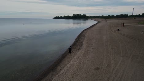Man-Running-At-The-Beach-In-Ontario,-Canada-At-Dusk