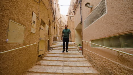 Tourist-Climbing-Down-The-Stairs-In-The-Old-Town-In-Ghardaia,-Algeria