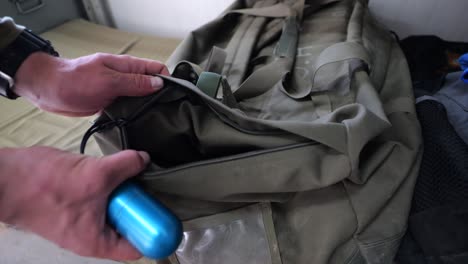 Soldier-putting-practice-grenade-in-and-out-of-duffel-bag,-close-up