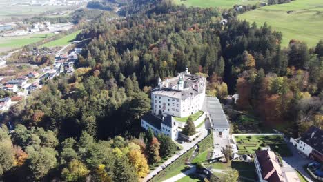 Ambras-castle-in-a-vertical-aerial-view-on-an-autumn-day-and-with-its-green-forests-and-the-tranquility-of-this-place-in-Tyrol-in-Austria