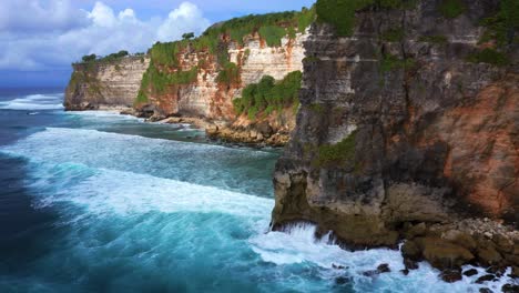 Uluwatu-Cliffs-On-Ocean-Coast-In-Bali-Island,-Indonesia---drone-shot