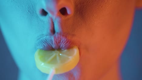 Nahaufnahme-Einer-Frau,-Die-Auf-Sinnliche-Und-Sexy-Weise-Die-Lippen-Eines-Gelben-Zitronenlutschers-Leckt