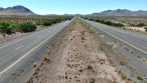 Aerial-dolly-forward-over-median-of-highway-in-desert