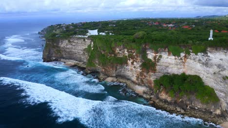 Waves-Crash-On-Sheer-Cliffs-Of-Uluwatu-Near-Jaran-Hill-In-South-Bali,-Indonesia