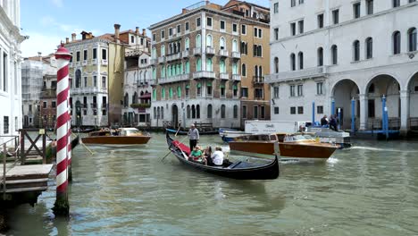 Góndola-Y-Taxis-Acuáticos-Navegando-Por-El-Gran-Canal-De-Venecia-Pasando-Por-El-Palacio-De-Los-Camarlenghi.