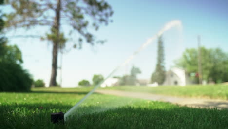 Ground-Level-View-of-Sprinkler-Forcefully-Watering-Park-Grass
