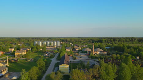 A-drone-flies-over-a-small-town-with-steel-silos-in-the-distance