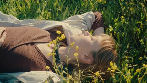 Carefree-woman-lying-in-field-with-wildflowers-enjoys-feeling-sun-on-her-skin