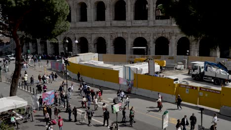 Mit-Blick-Auf-Touristen,-Die-Entlang-Der-Piazza-Del-Colosseum-Neben-Gelben-Bautafeln-Spazieren