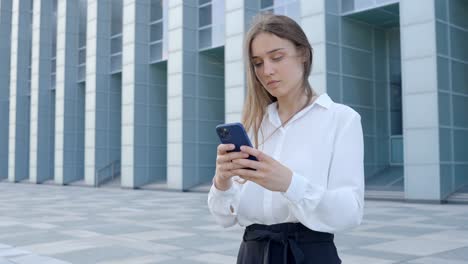 Texting-Radiant-Nordic-Woman-Engaged-in-Phone-Text-by-Office-Building,-Serious,-and-Professional
