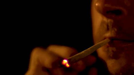 4K-60fps-closeup-of-caucasian-male-smoking-cannabis-spliff-joint-during-night