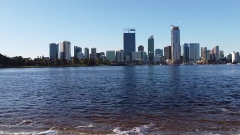 Drone-shot-rising-over-Swan-River-with-view-of-skyline-of-Perth,-Western-Australia