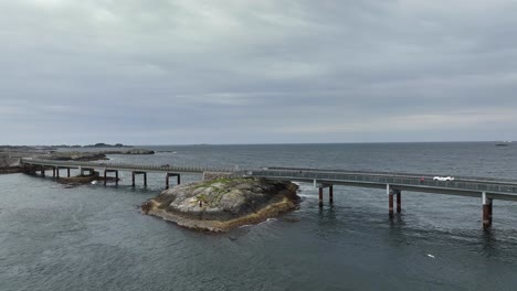 Myrbaerholm-bridge-with-Atlantic-Ocean-in-background-along-the-world-famous-Atlantic-Ocean-Road-in-Norway---Panoramic-aerial-presenting-bridge-while-moving-gently-forward-and-to-left