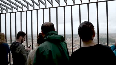 Tourists-At-Top-Of-St-Peter's-Basilica-Taking-Photos-Through-Railings-Overlooking-The-Vatican