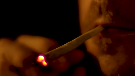 4K-closeup-of-Caucasian-male-smoking-cannabis-spliff-joint-during-night