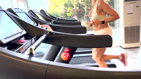 Adult-an-fit-woman-exercising-on-treadmill-in-gym