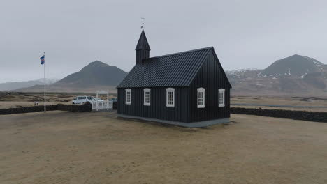 Drone-Shot-of-Black-Church-in-Búðir,-Landmark-in-Landscape-of-Iceland