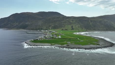 Alnes-lighthouse-on-peninsula-covered-by-Atlantic-ocean-outside-Alesund-Norway---Aerial-from-seaside-looking-towards-lighthouse-and-shoreline