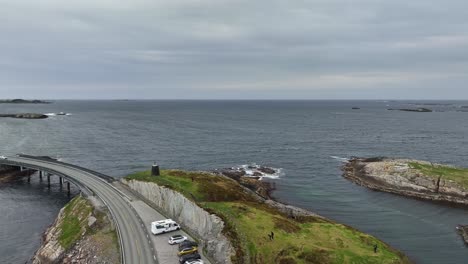 Atlantic-Ocean-Road-Norway---Reverse-aerial-from-Ocean-horizon-to-revealing-tourist-parking-parking-spot-with-caravans-on-Skipsholmen-island