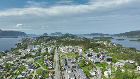 Spjelkavik,-Hatlanda,-Breivik-and-Moa-residential-area-close-to-the-Asefjord-righ-next-to-Alesund-Norway---Summer-aerial-above-island-leading-to-Alesund