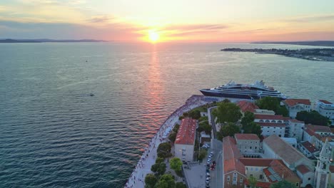 Imágenes-De-Drones-Puesta-De-Sol-Sobre-El-Adriático-En-Zadar,-Croacia-Con-Un-Barco-De-Lujo-Atracado-Y-Tejados-Rojos