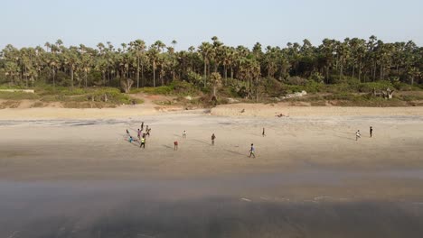 Niños-Gambianos-Jugando-Al-Fútbol-En-La-Playa,-Filmados-Por-Un-Dron