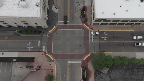 Intersection-with-cars-moving-in-downtown-Bristol,-Indiana-with-drone-video-looking-down-stable
