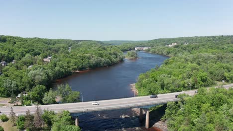 Aerial-wide-reverse-pullback-shot-above-the-Saint-Croix-River-in-Taylors-Falls,-Minnesota