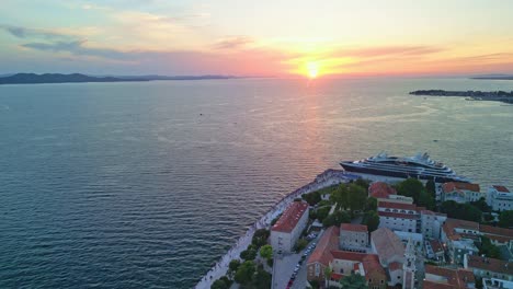 Forward-flying-drone-over-Zadar-in-sunset,-Croatia