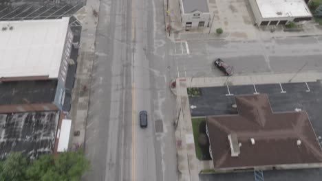 Downtown-Elkhart,-Indiana-with-cars-driving-and-drone-video-tilting-up