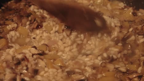 Cinematic-Close-Up-of-Chef-Stirring-Mushroom-Risotto-as-Vegetable-Stock-Bubbles