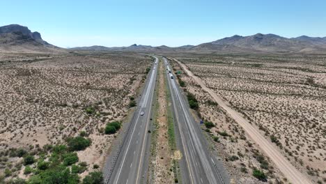 Aerial-rising-shot-of-highway-cutting-through-vast-desert-in-Southwest-USA