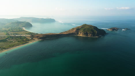 Luftaufnahme-Der-Küste-Der-Insel-Lombok-An-Einem-Sonnigen-Und-Nebligen-Tag---Drohnenpanoramablick-Auf-Das-Meerwasser-Und-Die-Felsige-Insel
