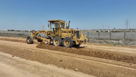 Luftdrohnenaufnahme-Einer-Caterpillar-Hochleistungsmaschine-Beim-Ausheben-Eines-Lochs-Für-Die-Rohrverlegung-In-Karatschi,-Pakistan