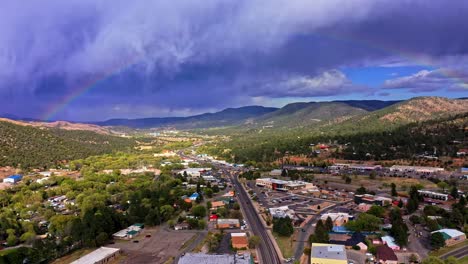 Rainbow-over-a-city-surrounded-by-vegetation-and-mountains