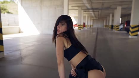 Dancing-sexy-woman-performs-modern-dance,-posing,-twerking-in-parking-zone.-Close-up