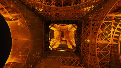 Atemberaubende-Aussicht-Unter-Dem-Beleuchteten-Eiffelturm,-Der-Sich-Auf-Die-Olympischen-Spiele-Vorbereitet,-Nachts-In-Paris,-Frankreich