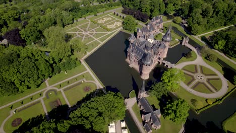 Slow-rotating-aerial-showing-historic-picturesque-castle-Ter-Haar-in-Utrecht-with-typical-towers-and-fairy-tale-cants-facade-exterior-on-a-bright-day-with-landscaping-gardens-in-the-foreground