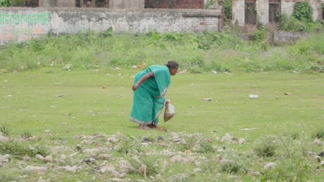 Poor-and-lonely-old-woman-picking-up-wastes-from-ground
